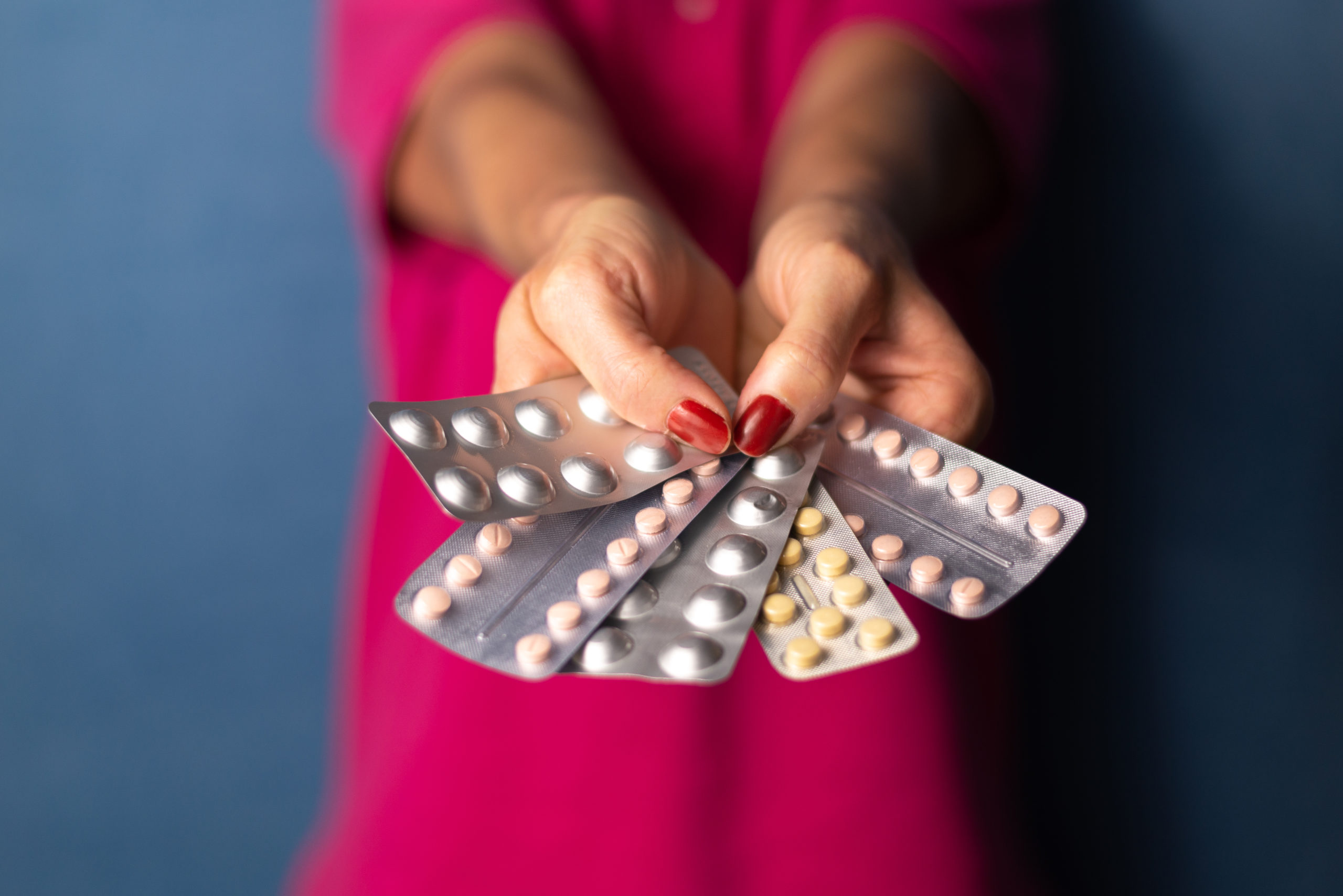 A woman holds several pill packs in her hands in a fan shape |The Well med spa