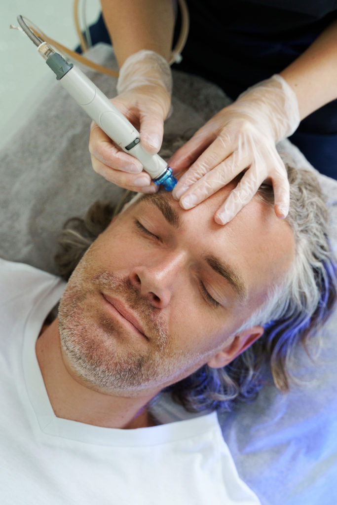 Middle aged man during deep facial cleansing in a cosmetology cl